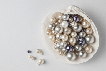 Various pearl beads in a large shell - obrazy, fototapety, plakaty