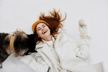 cheerful woman in the snow playing with a dogs fun friendship winter holidays