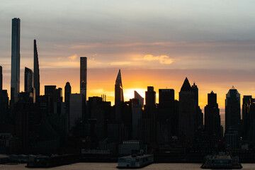 Fototapeta na wymiar Stunning morning sunrise over Manhattan skyline in silhouette and vivid sky-clouds.