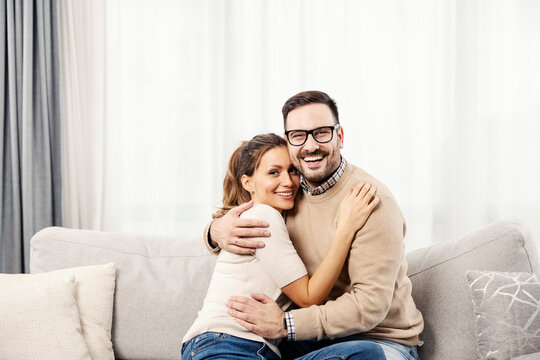 A happy couple hugging and enjoying time together at their new home.