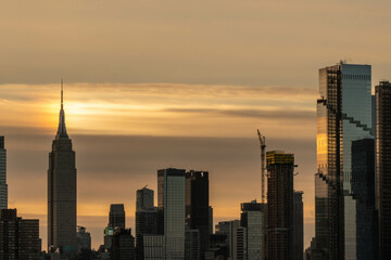 Stunning morning sunrise over Manhattan skyline in silhouette and vivid sky-clouds.