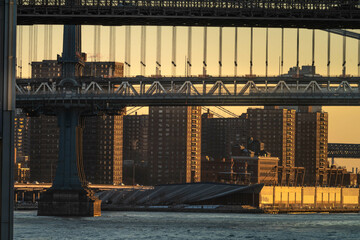Warm perfect morning sun hitting NYC buildings under a Brooklyn bridge, sunrise in the city
