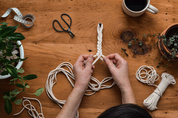 Top down view of woman making macrame plant hanger