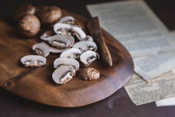 Organic Cremini Mushrooms Sliced and Whole on a Wooden Cutting Board