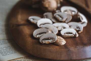 Organic Cremini Mushrooms Sliced and Whole on a Wooden Cutting Board