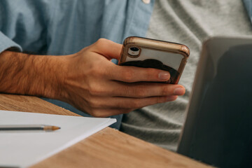 closeup of hands with mobile phone and computer