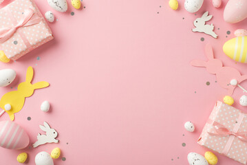 Obraz na płótnie Canvas Top view photo of easter decorations gift boxes confetti easter bunnies pink yellow and white easter eggs on isolated pastel pink background with copyspace