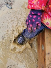 Kind mit Gummistiefel in Matsch Pfütze. Kind spielt im Matsch. Child with rubber boots in mud...