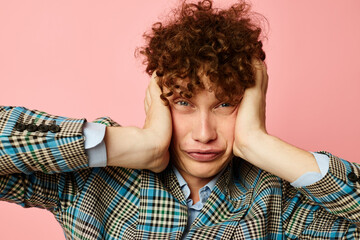 guy with red curly hair in a suit business look posing emotions pink background unaltered