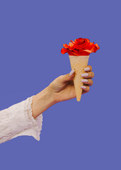 Female hand holding Ice cream waffle cornet with red glittering rose over very peri background. Minimalism dessert. Copy space. Minimal modern creative Valentine's love concept. Creative idea.
