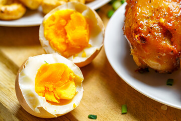 tasty and healthy food, lunch in rural style - boiled eggs, fried chicken meat and unpeeled potatoes, cooked food on a wooden kitchen board