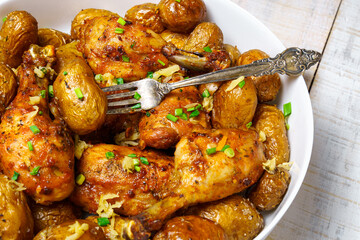 tasty lunch in rural style, healthy food - fried chicken meat and unpeeled roasted potatoes, chopped leeks, cooked food as background