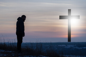 Cross. Crucifixion, Jesus. Silhouette, Man near the cross. Prayer, repentance for sin....