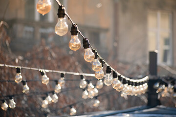 many light bulbs on the wire. lighting in the cafe. garland of lamps