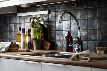 Still life kitchen interior design. A moody kitchen with herbs and spices and a loaf of bread. Water tap