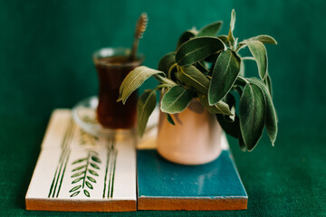 Sage tea in glass teacup and sage leaves on green background. Sage leaves. Medicinal herb. Spring...