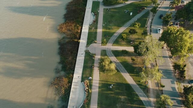 Coastal sunset over Park and river, cars, people and trees Fly aerial Drone 4k - Argentina Buenos Aires Zarate