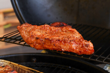 Marinated pork on the hot grill during a summer day. Barbecue party - crispy meat on the grill on the terrace.