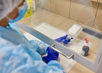 Anesthesiologist Doctors hand inject syringe into mixing normal saline solution bottle.