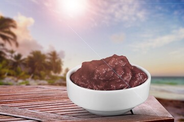 Acai bowl with lens flare on tropical beach background