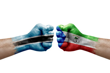 Two hands punch to each others on white background. Country flags painted fists, conflict crisis concept between botswana and equatorial guinea