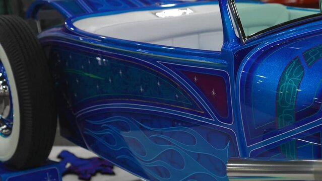 This panning video shows a blue metal flake hotrod car.