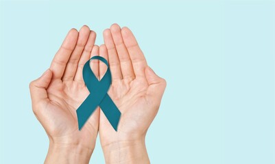 Teal awareness ribbon awareness for Ovarian Cancer month, hand with ribbon