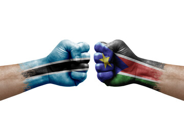 Two hands punch to each others on white background. Country flags painted fists, conflict crisis concept between botswana and south sudan