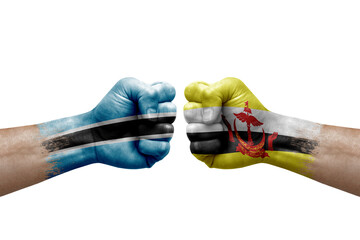 Two hands punch to each others on white background. Country flags painted fists, conflict crisis concept between botswana and brunei