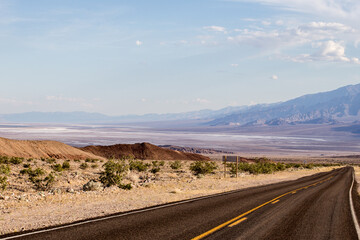 Empty road to the mountains in the desert, solitude on a road trip in the USA