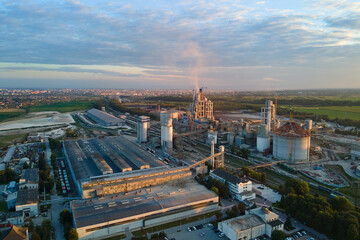 Aerial view of cement factory tower with high concrete plant structure at industrial production area. Manufacturing and global industry concept
