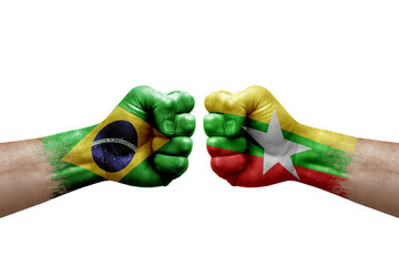 Two hands punch to each others on white background. Country flags painted fists, conflict crisis concept between brazil and myanmar
