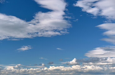 Bright landscape of white puffy cumulus clouds on blue clear sky