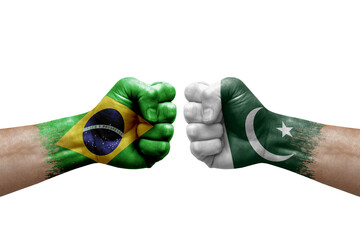 Two hands punch to each others on white background. Country flags painted fists, conflict crisis concept between brazil and pakistan