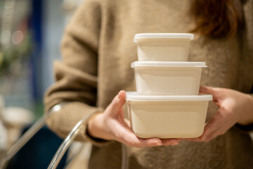 Closeup female hands holding stack of ceramic containers with plastic lid food comfortable storage