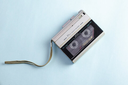 Gray cassette recorder with internal casset, isolated on blue background. 90s technology. Retro, vintage style. Copy space. 