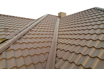 Detail of house roof structure covered with brown metal tile sheets.