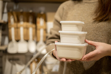 Closeup female hands holding stack of ceramic containers with plastic lid food comfortable storage