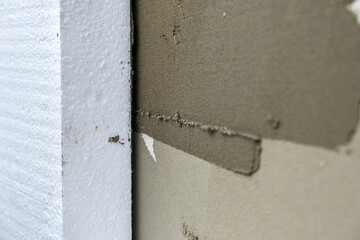 Installation of styrofoam insulation sheets on house facade wall for thermal protection