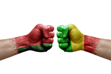 Two hands punch to each others on white background. Country flags painted fists, conflict crisis concept between belarus and mali