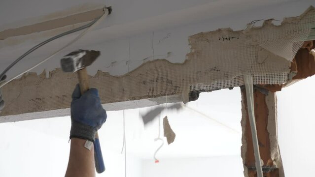 Man hitting a wall trying to remove a lintel during apartment remodeling