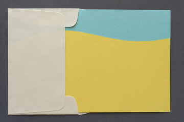 envelope (sideways) and paper design with wavy lines and blank space in yellow and blue