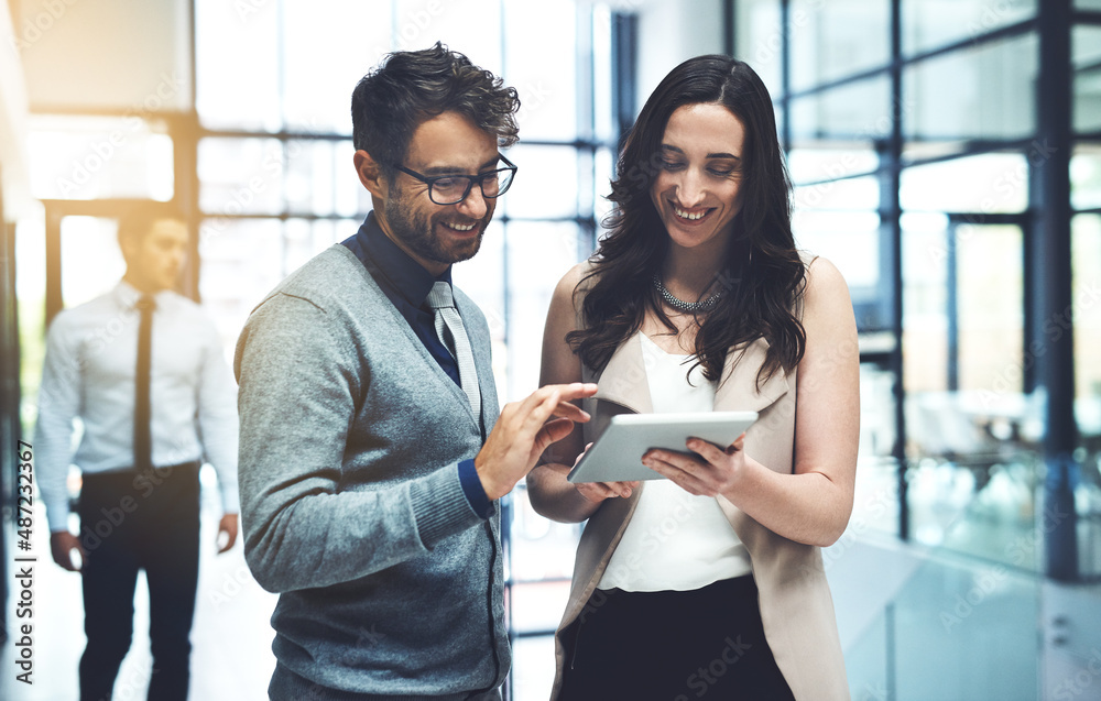 Aufkleber working with twice the expertise. shot of two businesspeople working on a digital tablet in a busy o