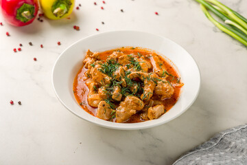 Goulash with beef and carrots on white marble table