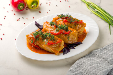 Stuffed cabbage on plate on white marble table
