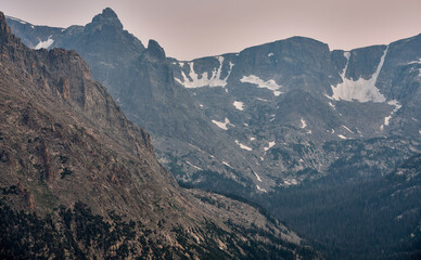 Craggy and snow covered mountain peaks and a deep glacial valley in the Rocky Mountains