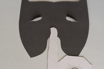 paper mask with pointing finger silhouette in gray