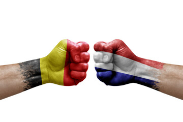 Two hands punch to each others on white background. Country flags painted fists, conflict crisis concept between belgium and netherlands - obrazy, fototapety, plakaty