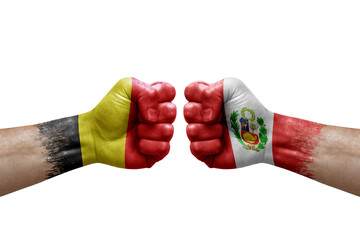 Two hands punch to each others on white background. Country flags painted fists, conflict crisis concept between belgium and peru