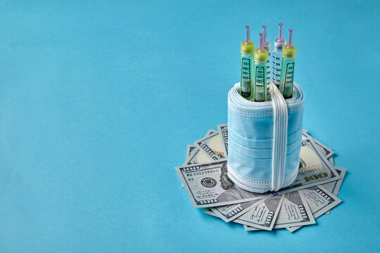 Insulin syringe pens wrapped in medical masks on dollar bills